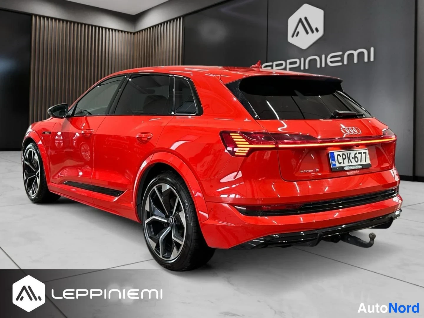 Takaviisto: Punainen Audi e-tron takaa kulmasta; takavalot, -rekisterikilpi ja takahana näkyvät.