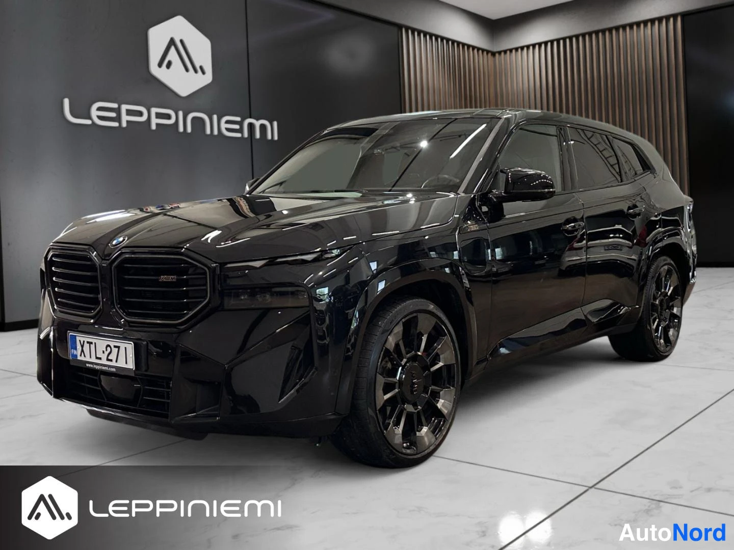 Etuviisto, nokka vasemmalle: BMW XM:n etuosa kolmivartalokulmassa vasemmalta, musta kori ja tummat kevytmetallivanteet.