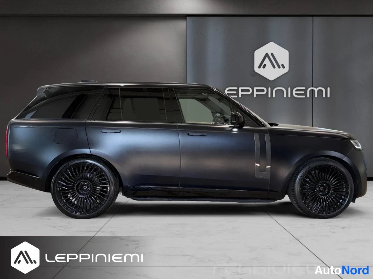 Sivulta: Land Rover Range Rover sivukuva oikealta puolelta, tummansävyinen koritäyttää kuvan myyntitilan lattialla.