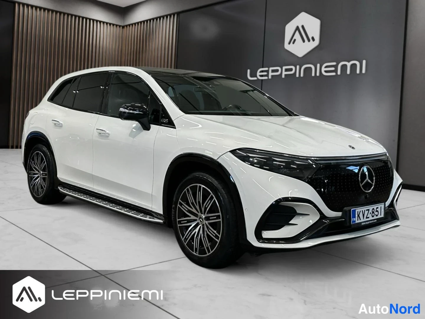 Etuviisto, nokka oikealle: Mercedes-Benz EQS SUV edestä oikealta vasemmalle kuvattuna, valkoinen korit ja musta etusäleikkö, rekisteritunnus.