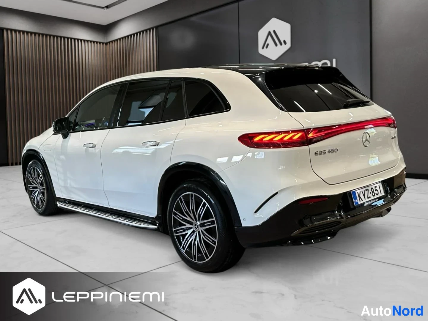 Takaviisto: Mercedes-Benz EQS SUV takaa vasemmalta kolmannesnäkymänä, valkoinen kori, rekisterikilpi ja takavalot näkyvissä.