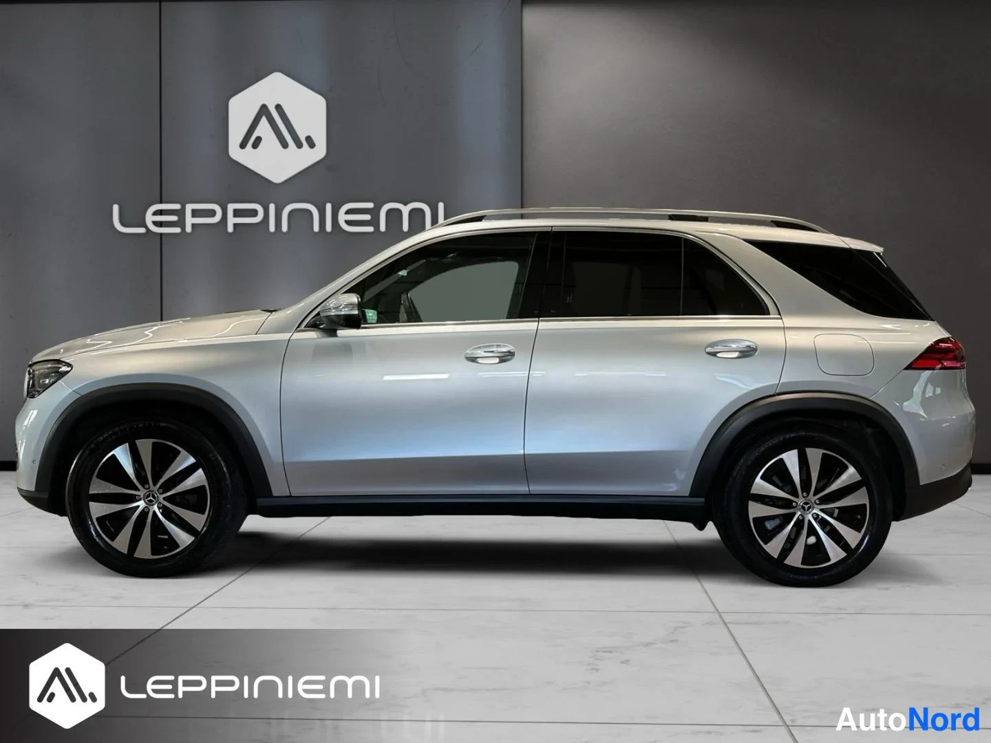Sivulta: Mercedes-Benz GLE:n vasen kylki suoraan sivulta; hopeanvärinen koriairalla, kattokiskot ja monipuoliset korin paneelit.