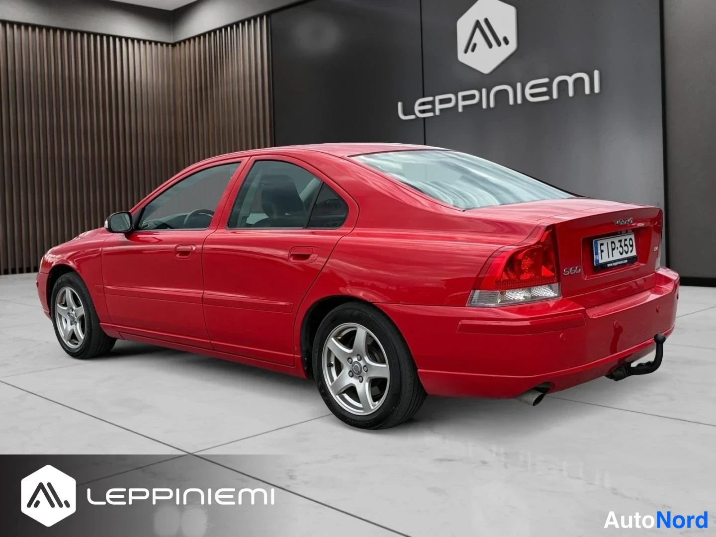 Takaviisto: Punainen Volvo S60 -sedan takaa-sivulta kuvattuna auton vasemmalta puolella, takavalot ja rekisteritunnus näkyvät.