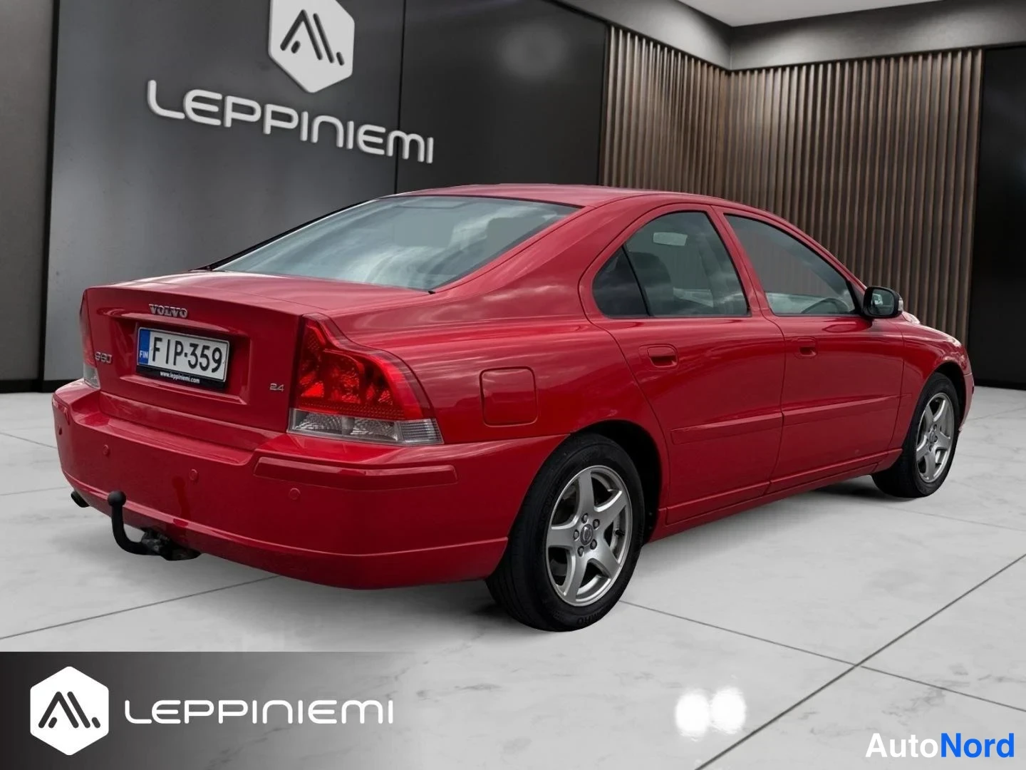 Takaviisto: Punainen Volvo S60 takaa-sivulta kuvattuna auton oikealta puolella, takavalot, rekisteritunnus ja vetoaisa näkyvät.