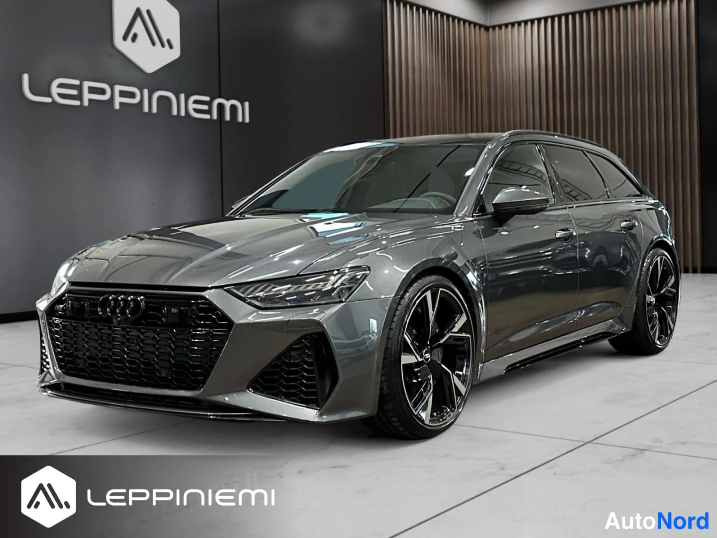 Etuviisto, nokka vasemmalle: Etukulmanäkyva harmaa farmariauto, keula vasemmalla, mustat vanteet ja musta etusäleikkö