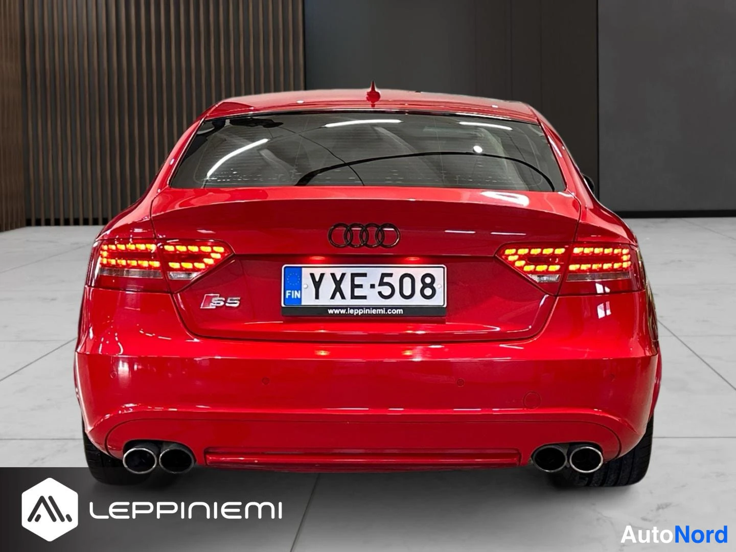 Takaa: Punaisen Audi S5:n takanäkymä: LED-takavalot, Audi-merkki, S5-tunnus, rekisterikilpi ja neljä pakoputkea.