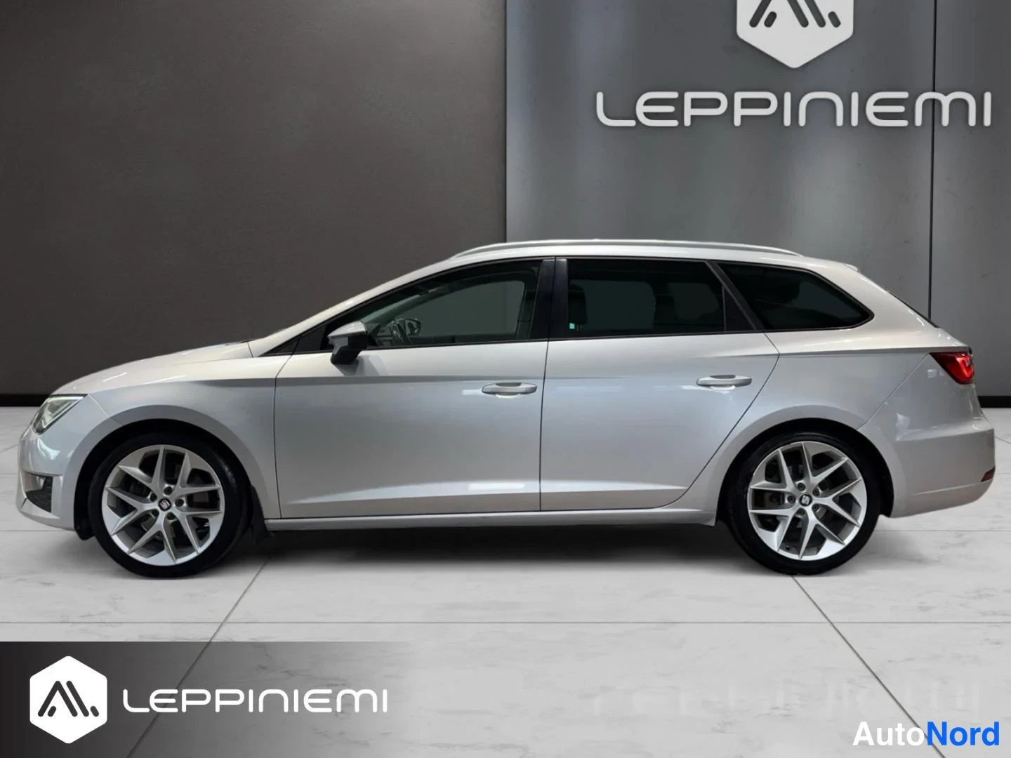 Sivulta: Seat Leon ST -farmarin sivunäkymä vasemmalta; hopea koriväri luettavissa oviaukkojen ja lokapeitteiden paneeleista, hopeat kevytmetallivanteet.