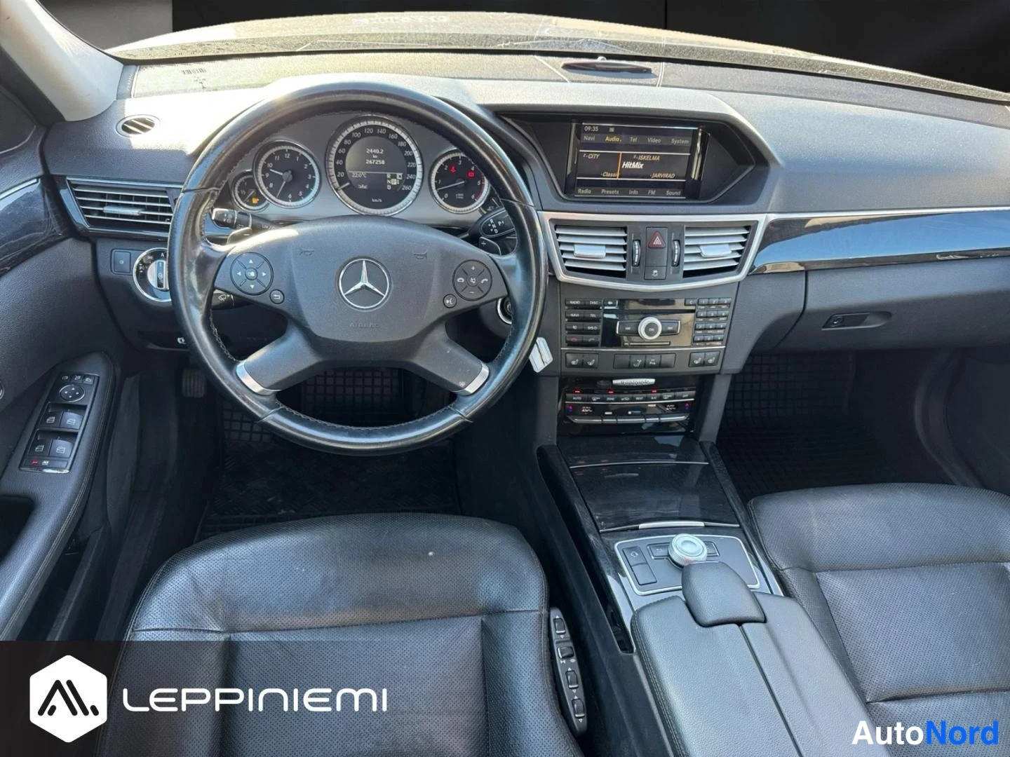 Muu: Mercedes-Benzin ohjaamo suoraan edesta: ohjauspyora merkeilla, mittaristo, keskinaytto ja keskikonsoli