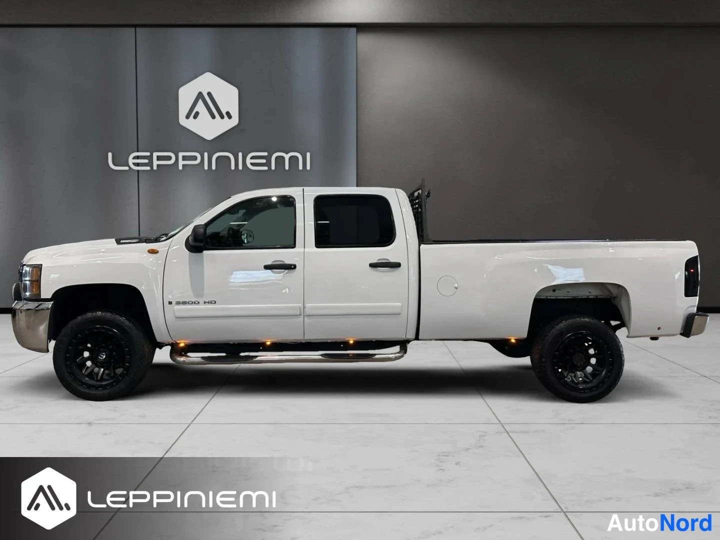 Sivulta: Valkoisen Chevrolet Silverado 3500 HD:n sivuprofiili, neljäovinen ohjaamo ja pitkä lava.