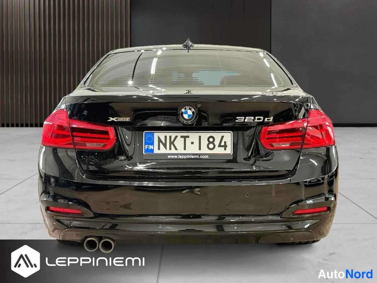Takaa: Musta BMW 320d -sedan takaa kuvattuna, rekisterikilpi, kaksoispakoputket näkyvissä.