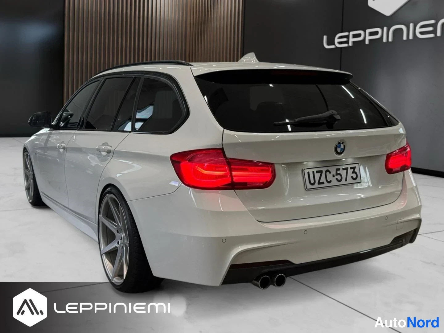 Takaviisto: BMW Touring -farmari vinosti takaa vasemmasta kulmasta: vaalea kori, punaiset takavalot, -rekisterikilpi ja suuret hopeanharmaat kevytmetallivanteet.