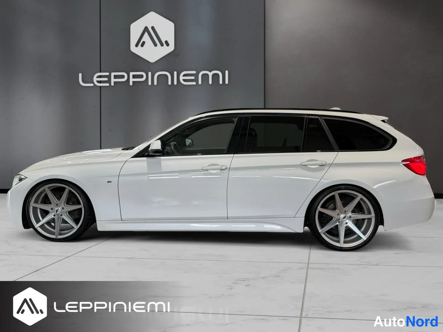 Sivulta: BMW Touring -farmarin sivuprofiili vasemmalta: vaalea kori, mustat ikkunakehykset ja katkaisu, suuret hopeanharmaat kevytmetallivanteet.