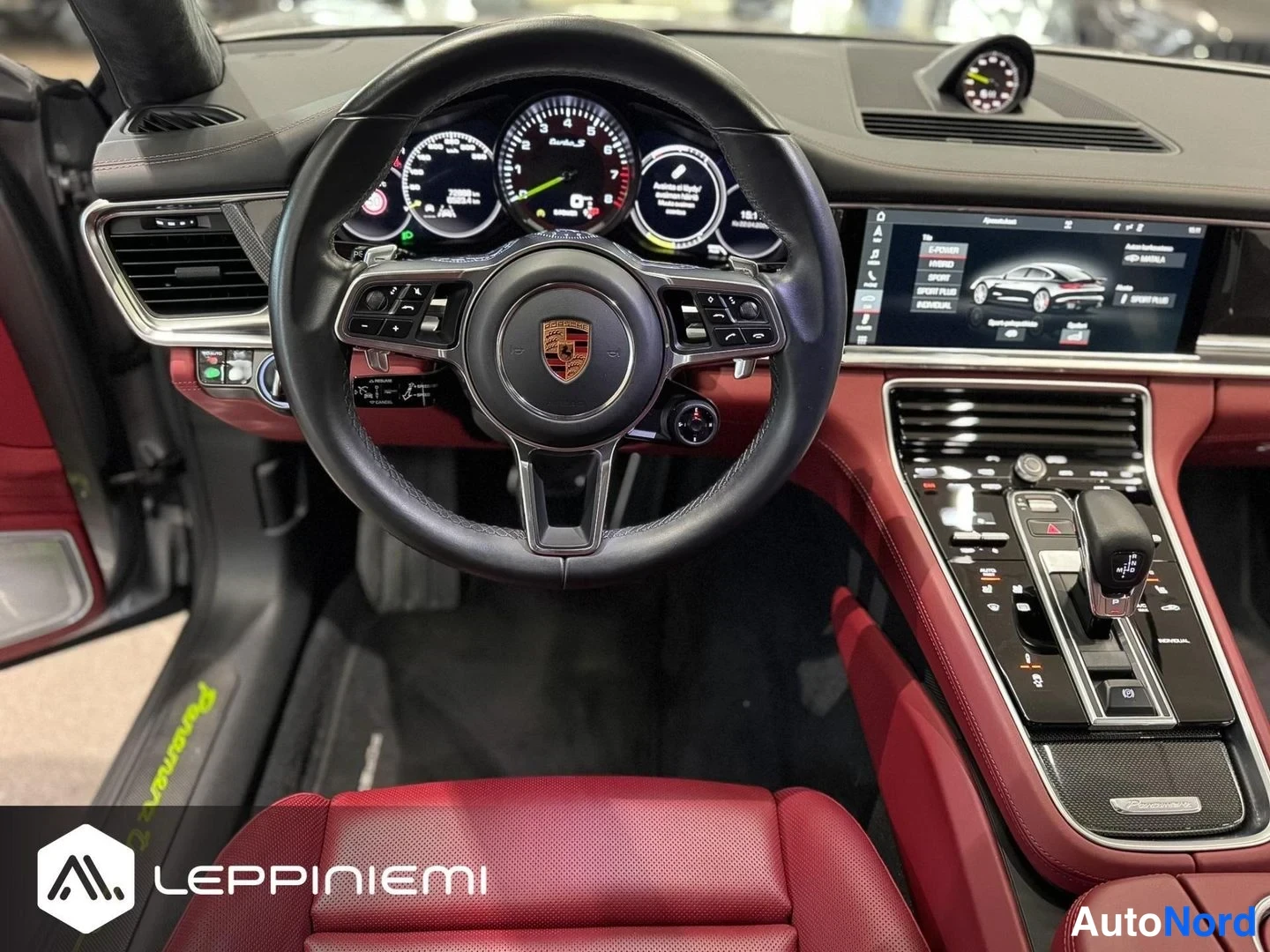 Muu: Ohjaamo punaisella nahalla: Porsche-ohjauspyörä, analogiset mittarit ja keskinäytöllä ajotilavalikko.