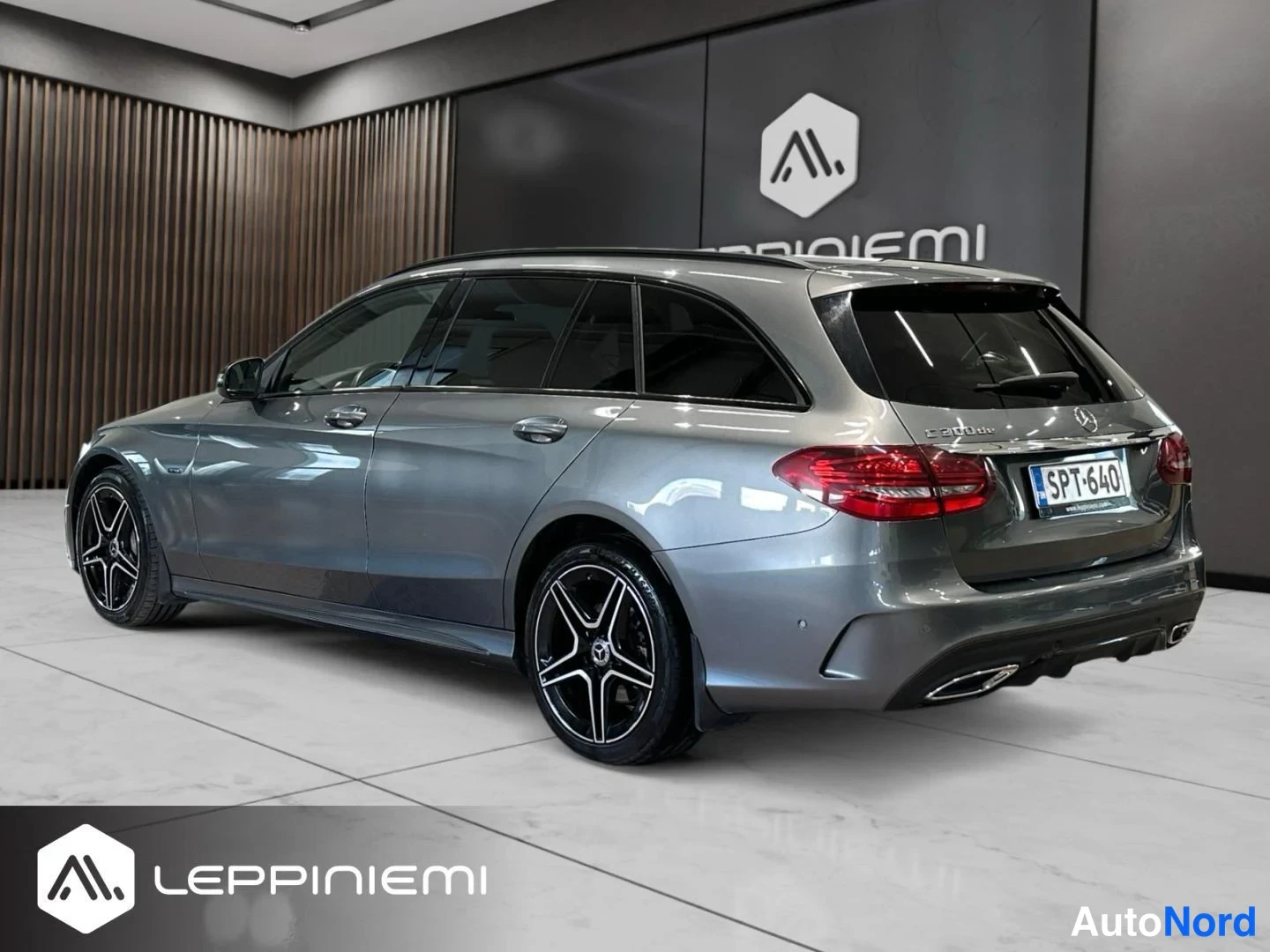 Takaviisto: Mercedes-Benz C 300 de -farmari takaa ja sivulta, harmaakomboinen runko, mustat AMG-vanteet, rekisteri.