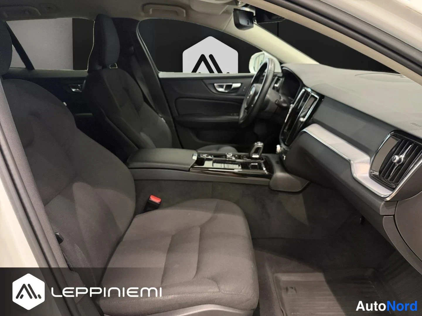 Muu: Volvo V60:n matkustamo takaa taakse katsottuna: etummat ja takapenkit tummassa kankaassa, keskikonsolin vaihtehan ja näyttö, tavaratilan muovimatto.