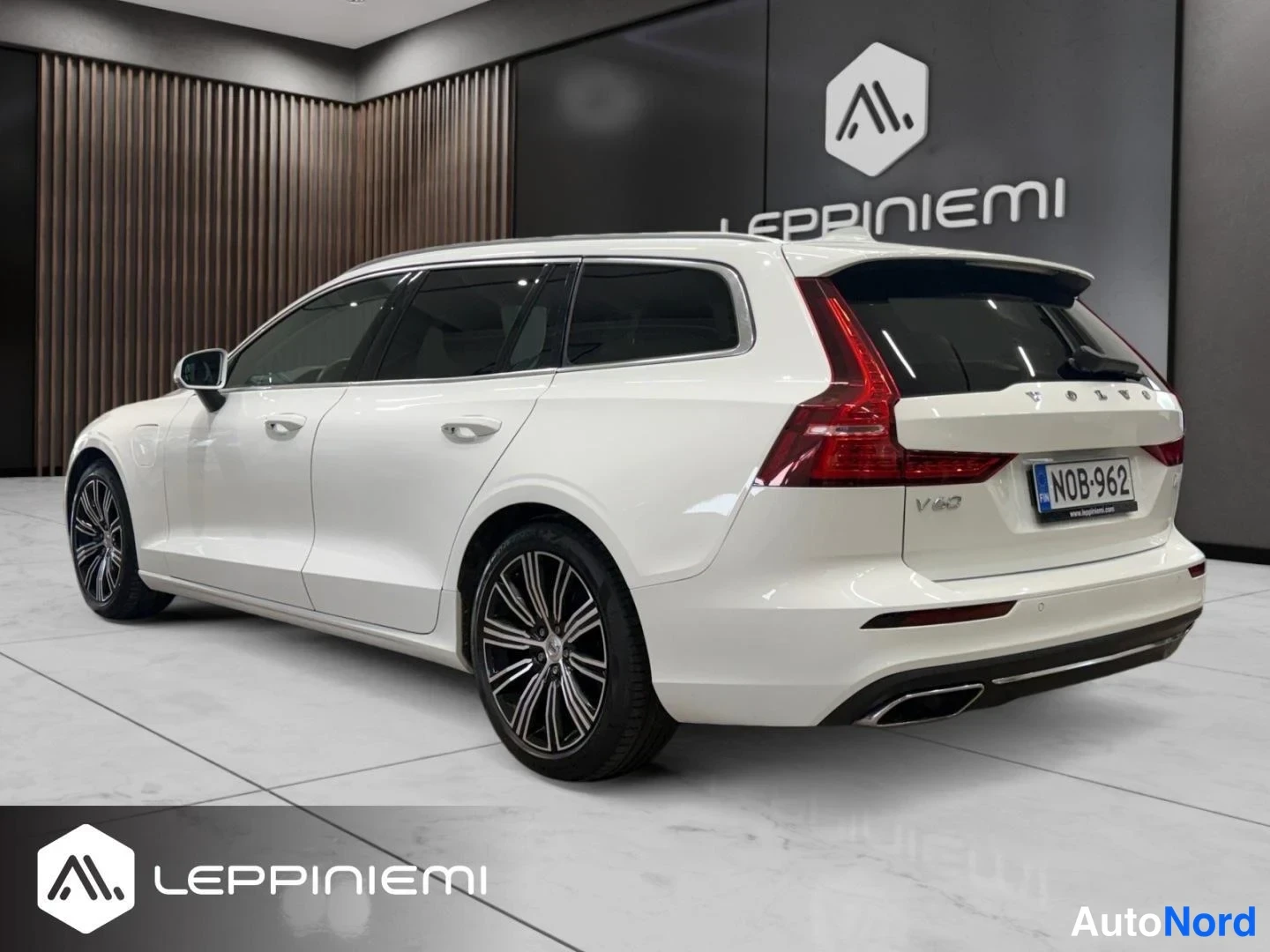 Takaviisto: Valkoisen farmariauton takakulmanäkymä sisätiloissa, rekisterikilpi.