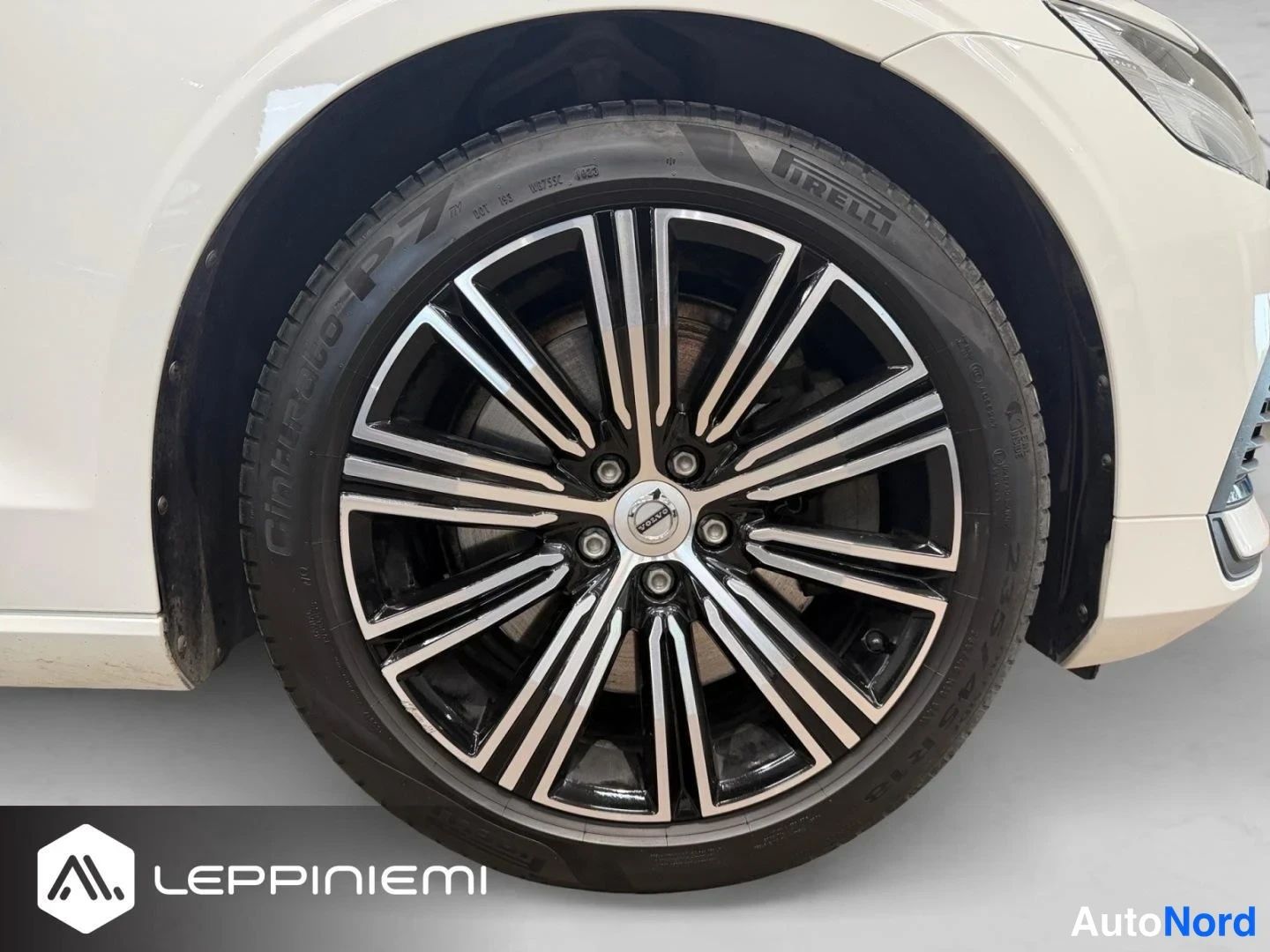Etuviisto, nokka oikealle: Volvo V60:n etupyörän detaljikuva: tumma monipuolainen kevytmetallivanne, Pirelli Cinturato P7 -rengas ja valkoinen etusarvi.