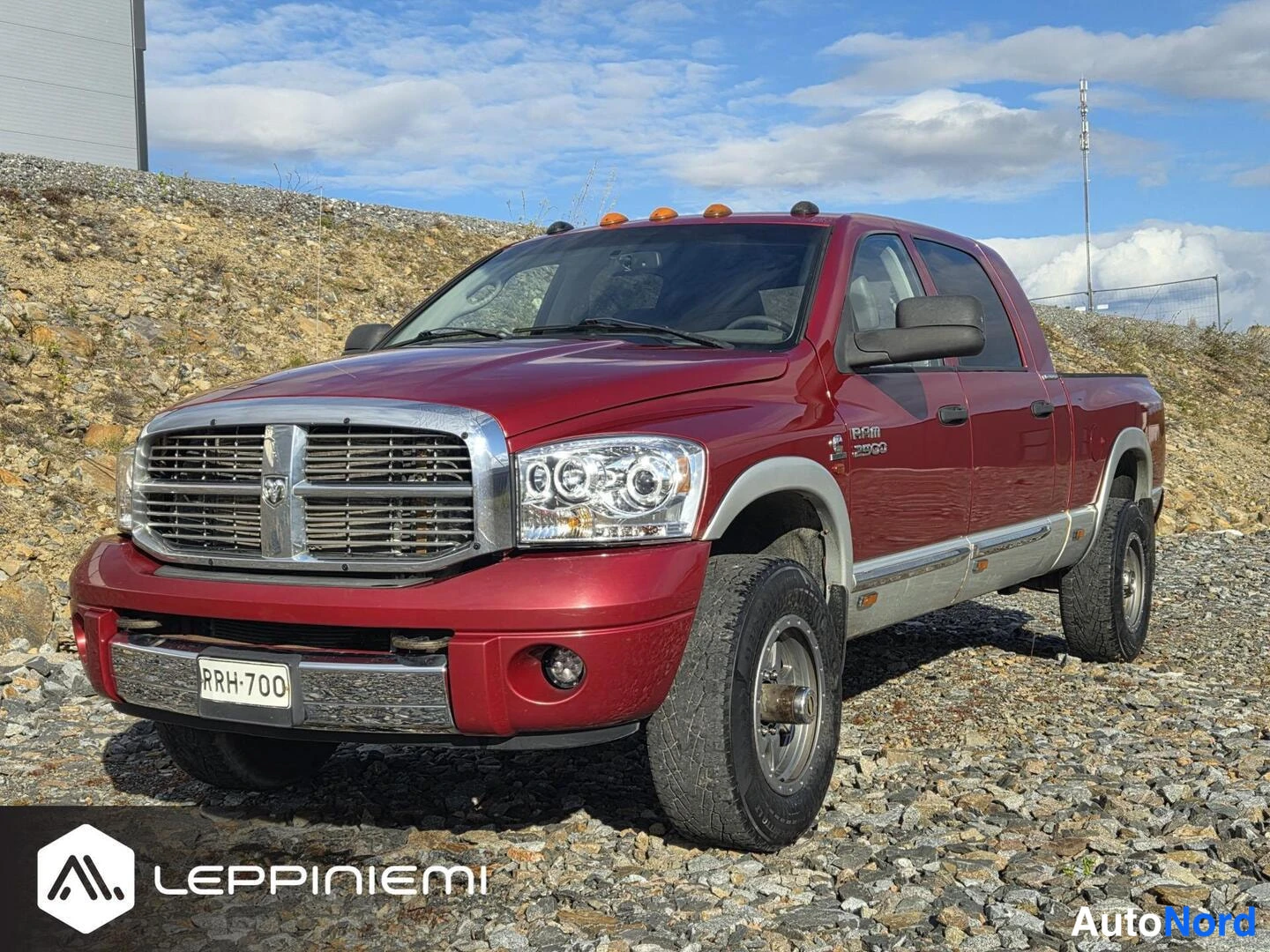 Etuviisto, nokka vasemmalle: Punainen Dodge Ram 2500 -n受aku etukulmasta, kromattu etusäleikkö ja -rekisterikilpi.