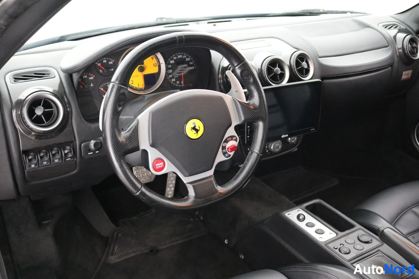 Muu: Ohjaamo oikealta: Ferrari-ohjauspyörä, kelta-musta mittaristo ja keskikonsoli.