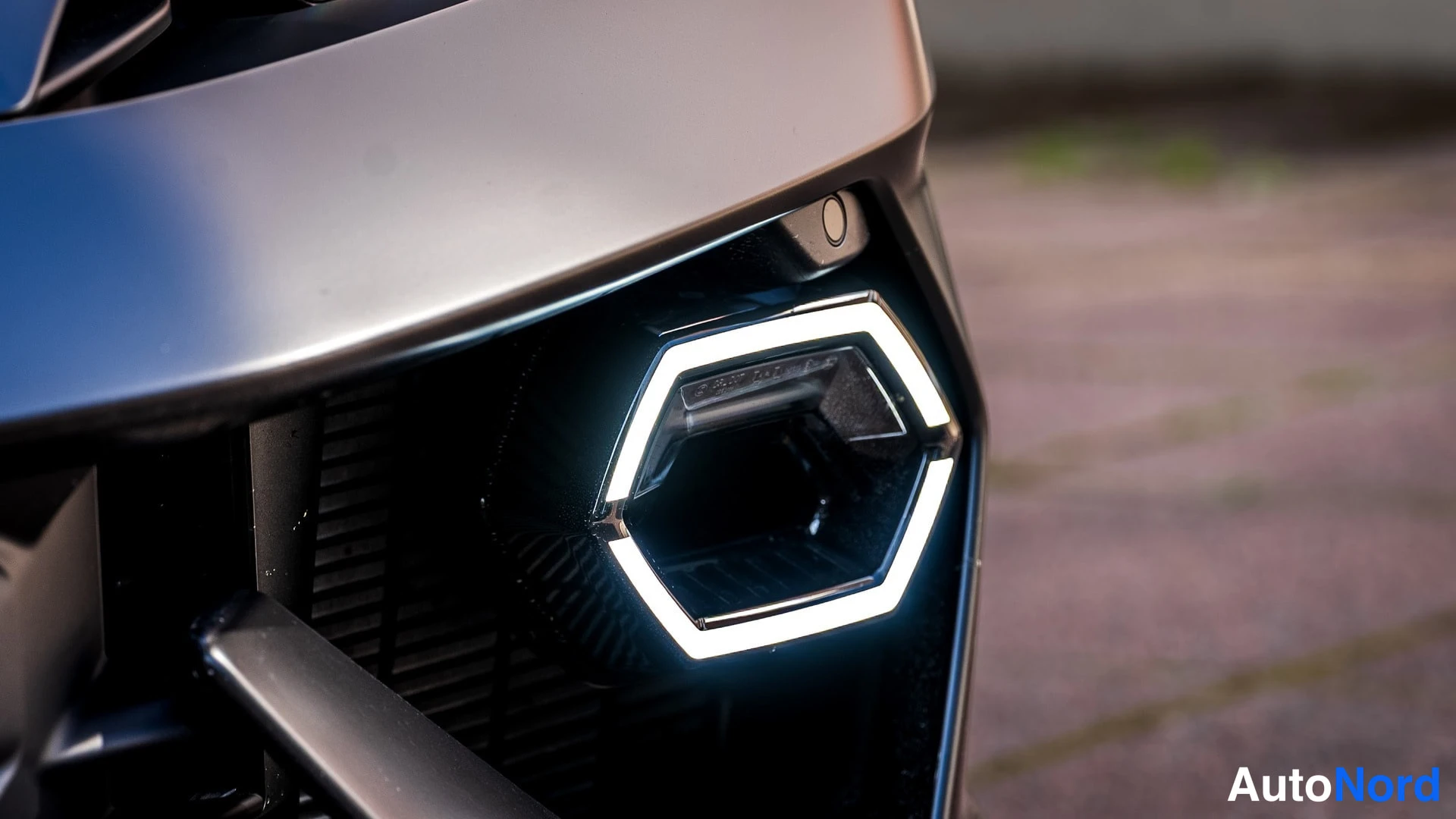 Edestä: Lähikuva auton etupään jäähdytysaukosta ja heksagonaalista LED-valoa