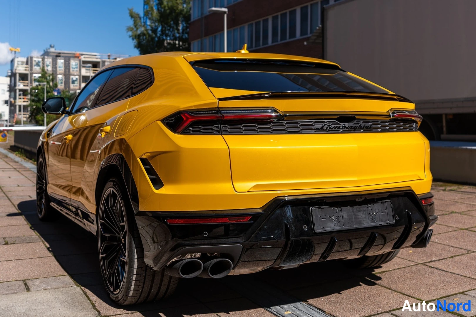 Takaviisto: Keltainen Lamborghini Urus takakulmasta, musta difuuseri ja neljä pakoputkea.