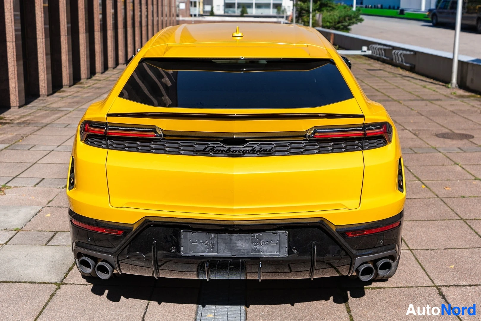 Takaa: Keltaisen Lamborghini Urus -maasturin takanäkymä: tummat takavalot, musta difuuseri ja neljä pakoputkea.