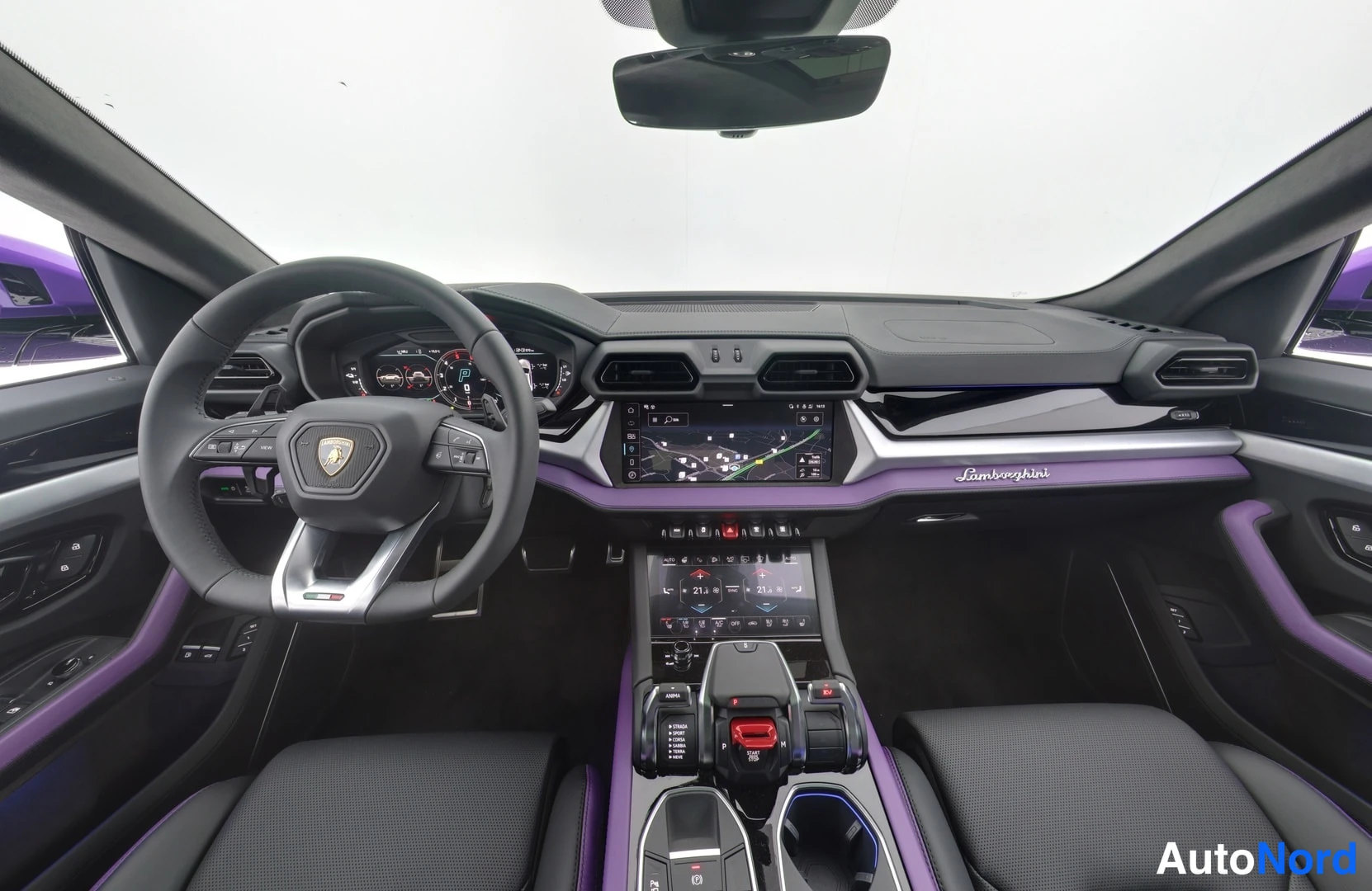 Takaviisto: Kojetaulu keskeltä: kosketusnäyttö, Lamborghini-ohjauspyörä, keskikonsolin vaihteenvalitsin ja violettikoristeet.