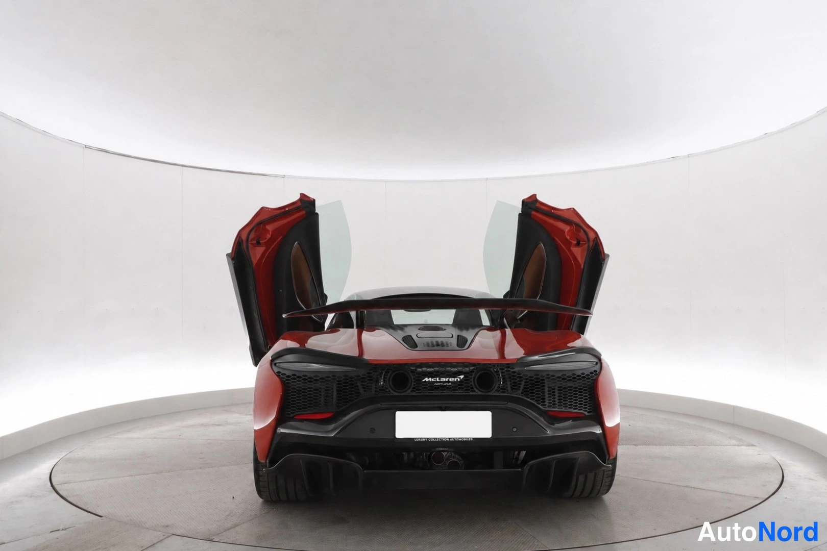 Takaa: Auton takaosa valokuvapiirissä, takapaneeli ja diffuusori näkyvät, McLaren-teksti takaluukussa.