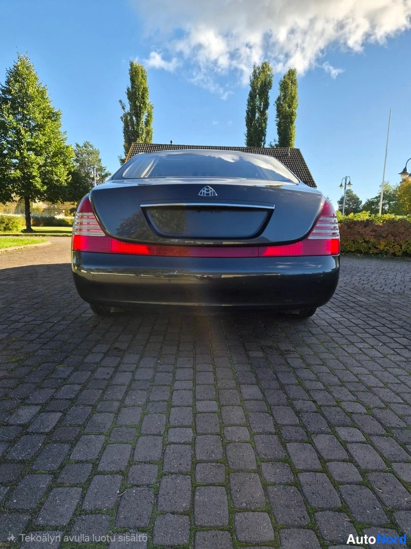 Takaa: Sedan takaosa suoralta takaa kuvattuna; punaiset takavalot ja tavaratilan kansi näkyvät, taivaalla pilviä.