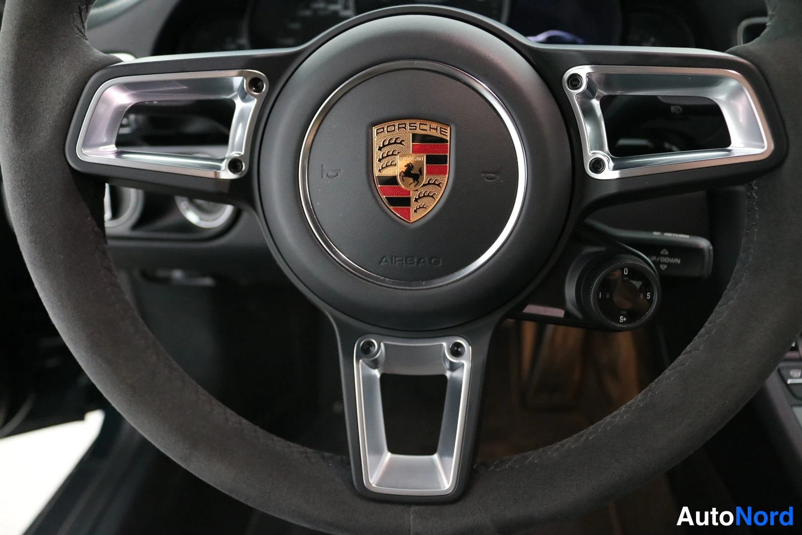 Muu: Porsche-ohjauspyörä, jossa tee-nahkaverhoilu ja Porsche-merkki keskellä; AIRBAG-teksti näkyy nappien yhteydessä.