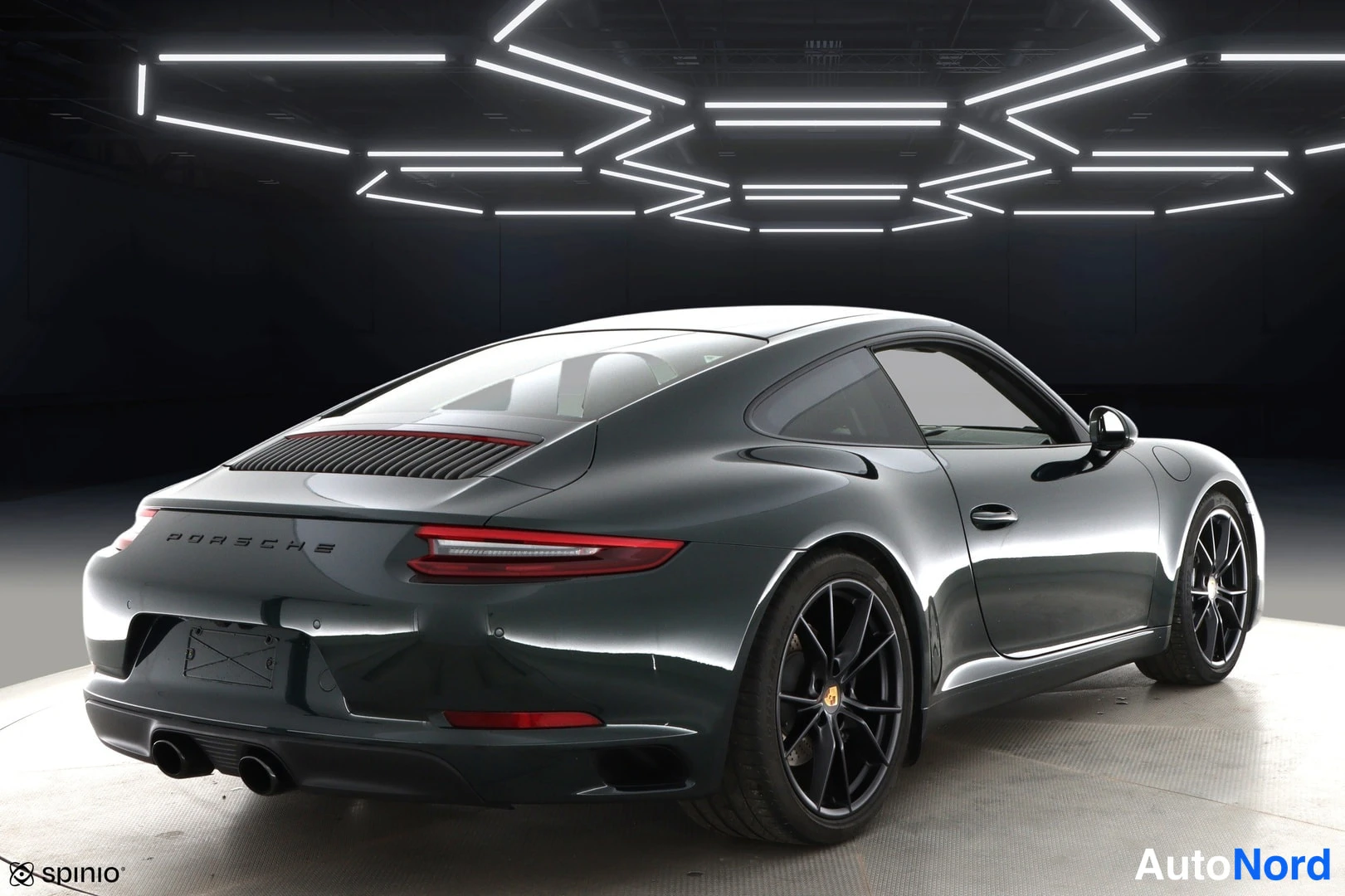 Takaviisto: Porsche 911 -coupén takakulmatarkastus, PORSCHE-teksti moottoritilan kannessa ja mustat kevytmetallivanteet.