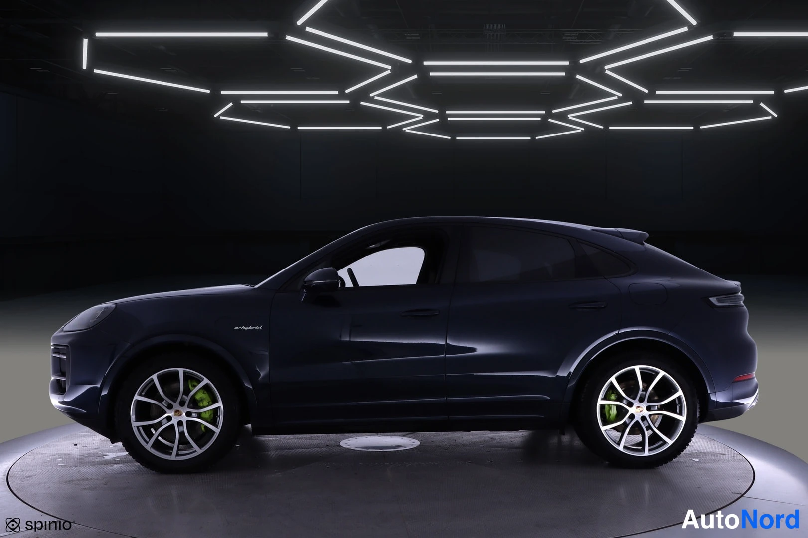 Sivulta: Tummansininen Porsche Cayenne Coupé sivulta vasemmalle nähtynä