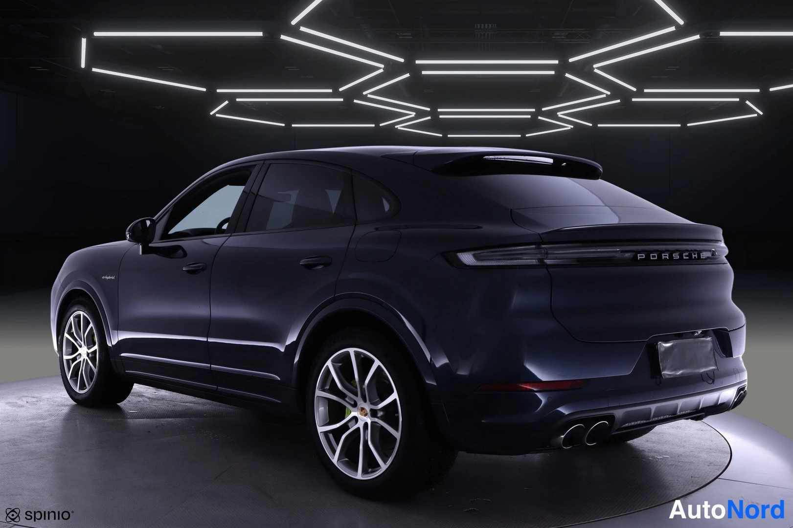Takaviisto: Tummansininen Porsche Cayenne Coupé takaongelmasta vasemmalle nähtynä studiovaiheessa