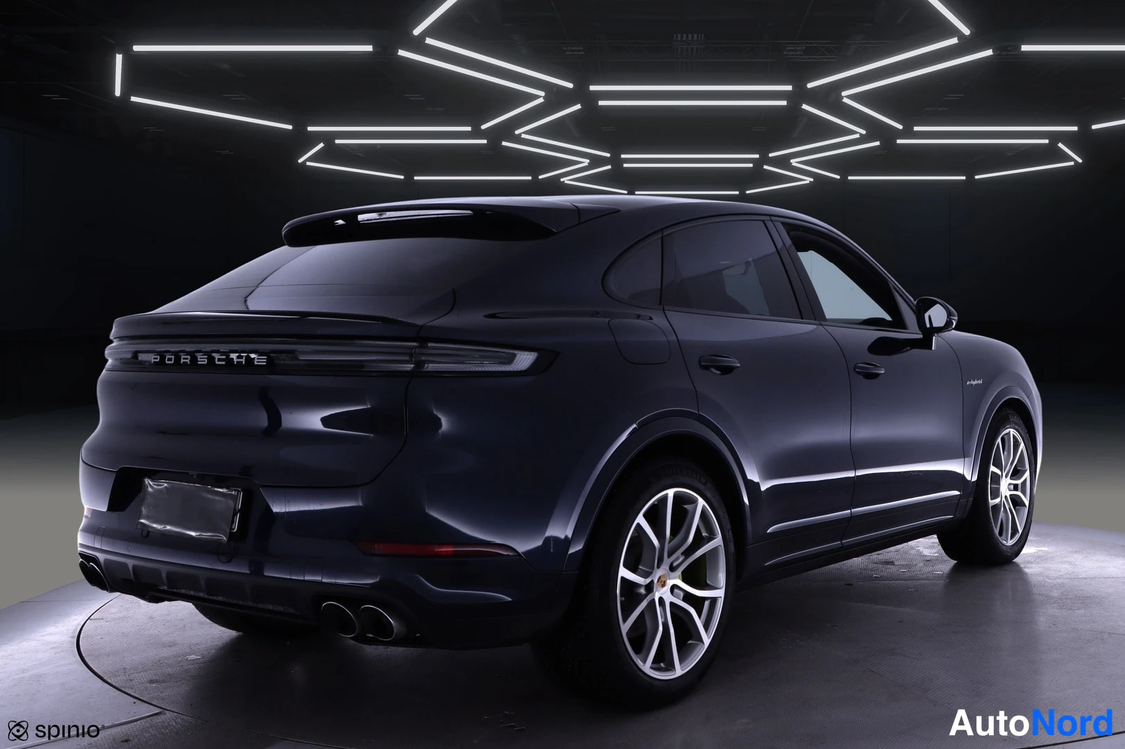 Takaviisto: Tummansininen Porsche Cayenne Coupé takaongelmasta oikealle nähtynä studiovaiheessa