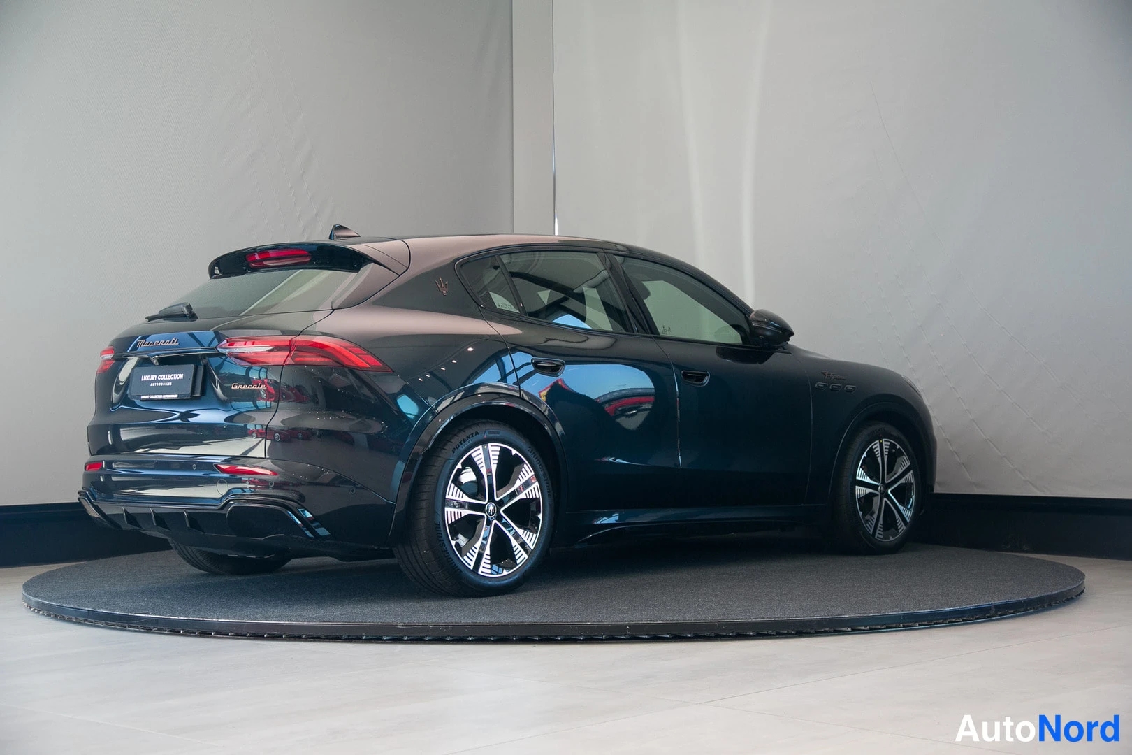 Takaviisto: Mustan Maserati Grecale -maasturin takakulma näkyy valokuvastudiossa pyörivällä alustalla.