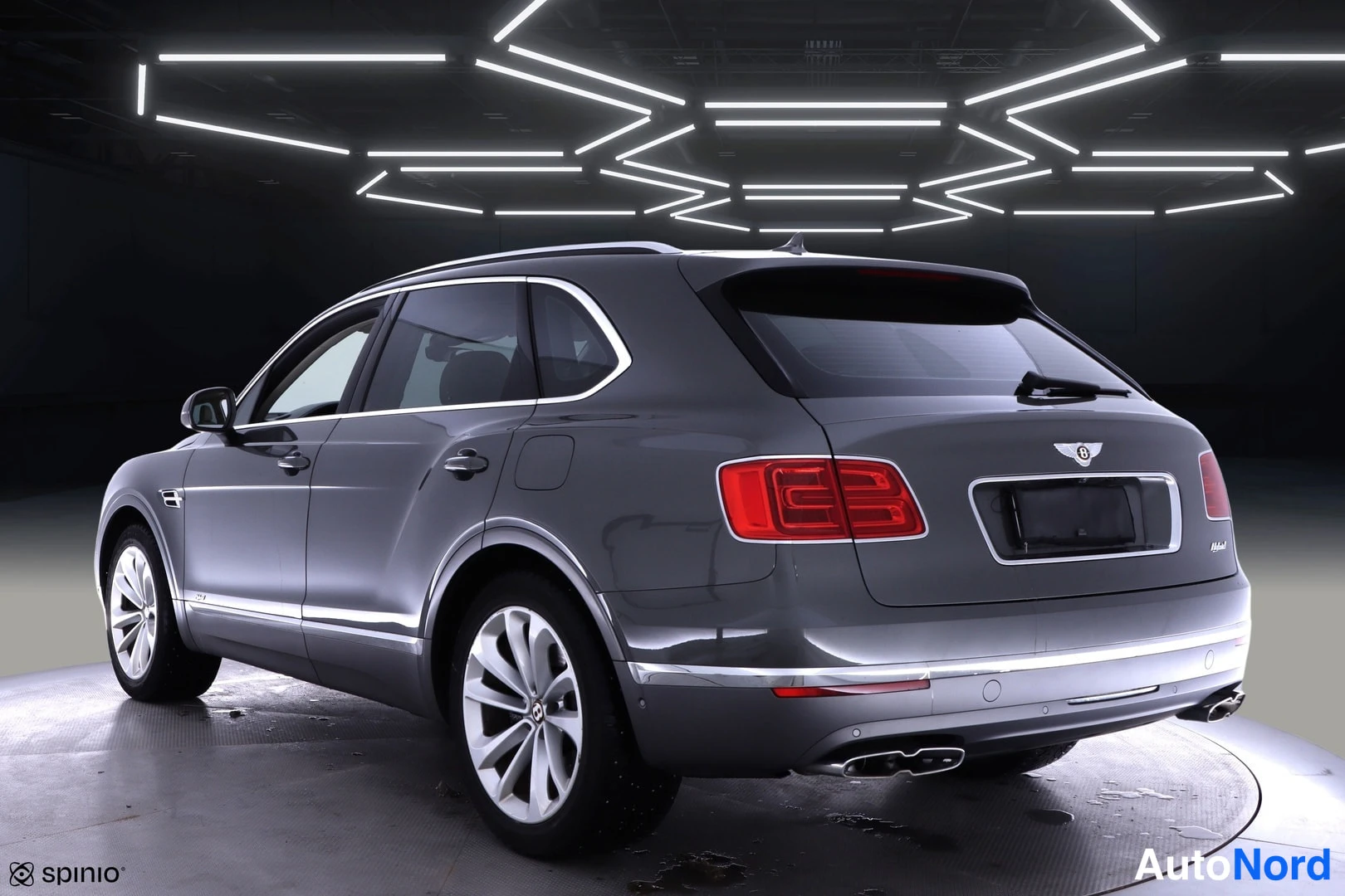 Takaviisto: Bentley Bentayga takakulma oikealta, punaiset takavalot ja neljä pakoputkea studiossa.