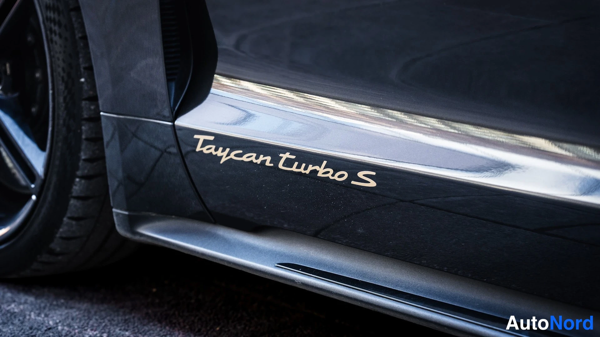 Sivulta: Sivokorin lähikuva, ovessa kultainen Taycan Turbo S -teksti, vasen etupyörä ja musta alusta näkyvät