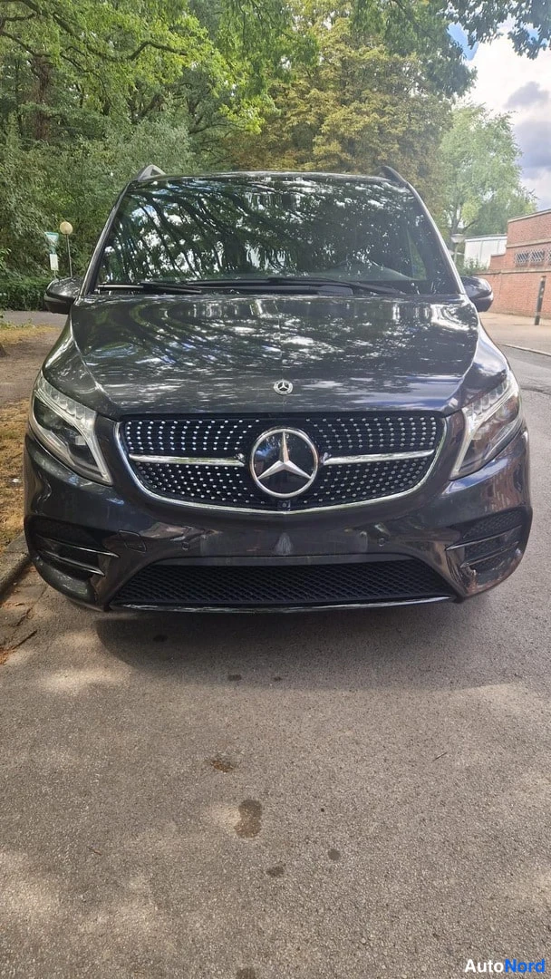 Edestä: Mercedes-Benz V -pakettiauto suoraan edestäpäin, tumma kori ja Mercedes-tähti keulakorissa.