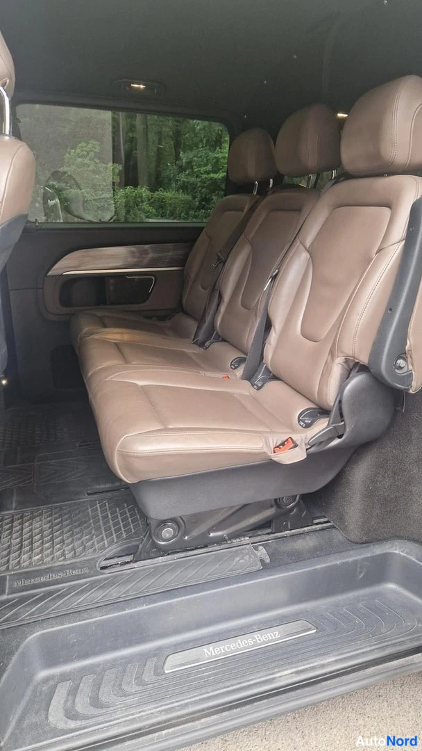Muu: Auton takaistuinrivi ruskeassa nahassa, kolme istuinta; oven kynnyksellä Mercedes-Benz-teksti.