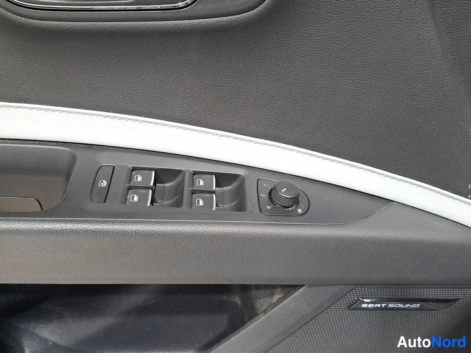 Yksityiskohta: Auton oven sisäpaneeli: ikkunankytkimet, peilin säätönuppi ja SEAT SOUND -kaiutinkuvio.