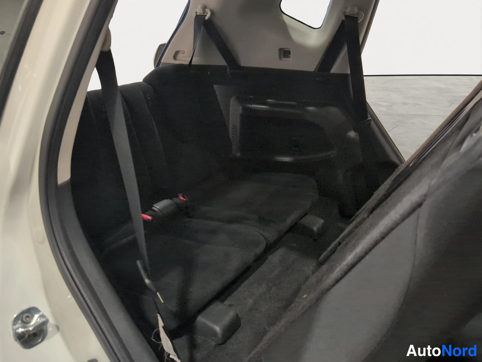 Muu: Nissan X-Trailin takaistuin takaa: tummat istuimet, turvavyöt ja kangaspäällyste.