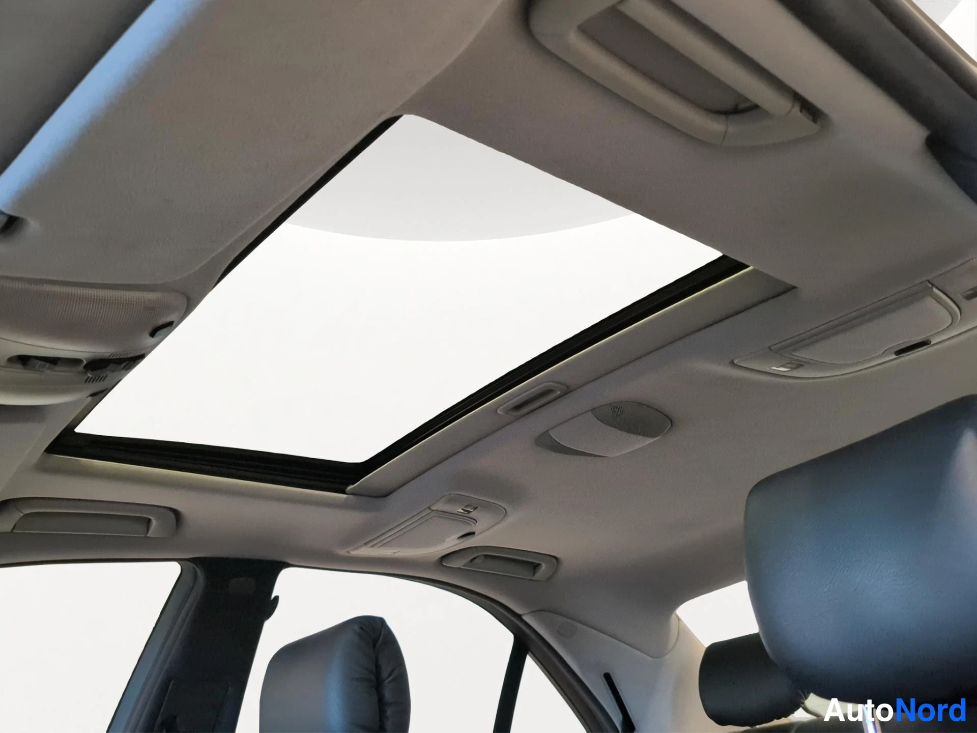 Muu: Kattoluukku avatussa asennossa, sisäkatto vaalea, takana nahkapäänojat.