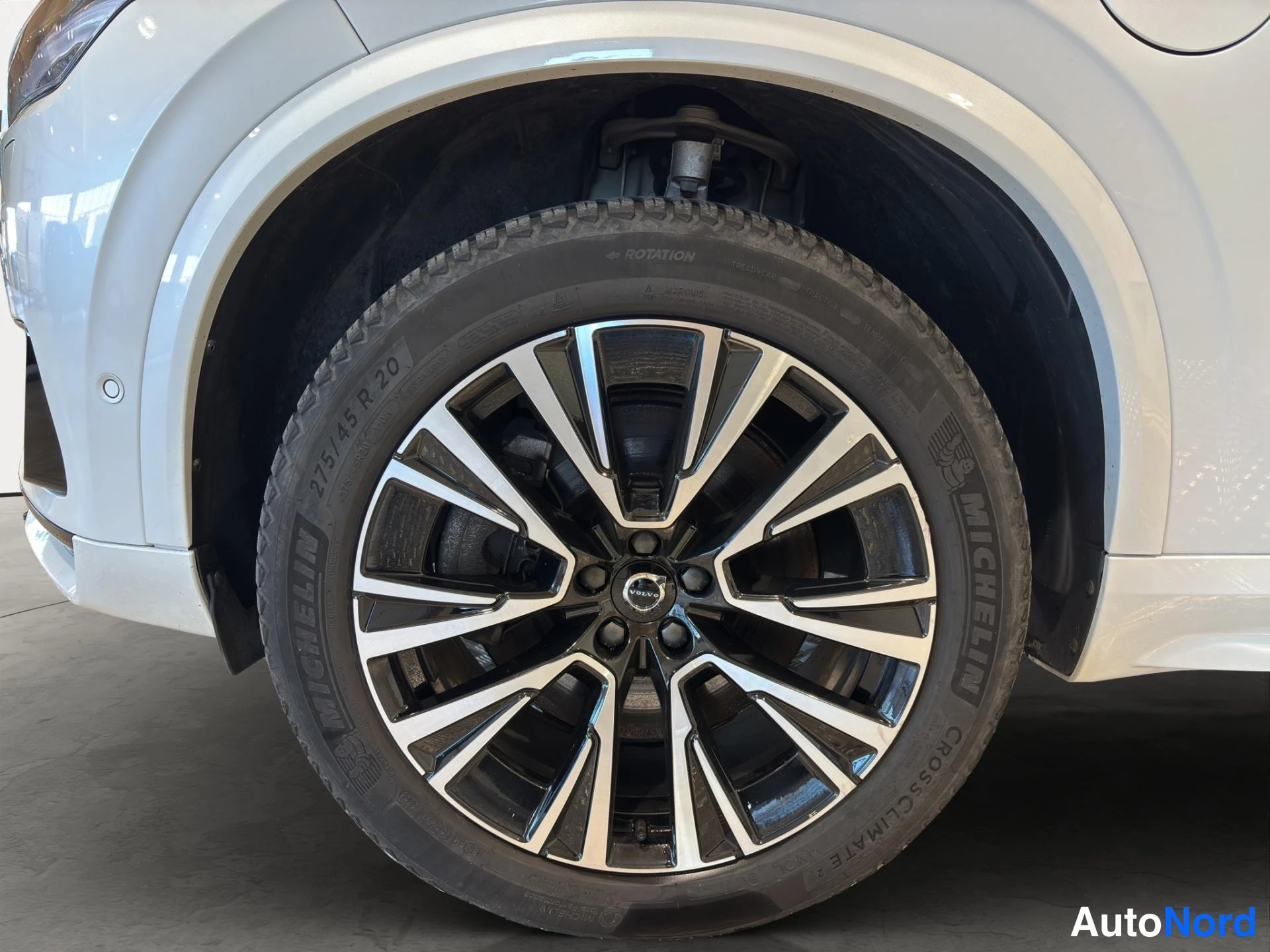 Sivulta: Valkoisen auton etupyörä lähikuvassa, Michelin CrossClimate -rengas ja 275/45 R 20 -merkintä.