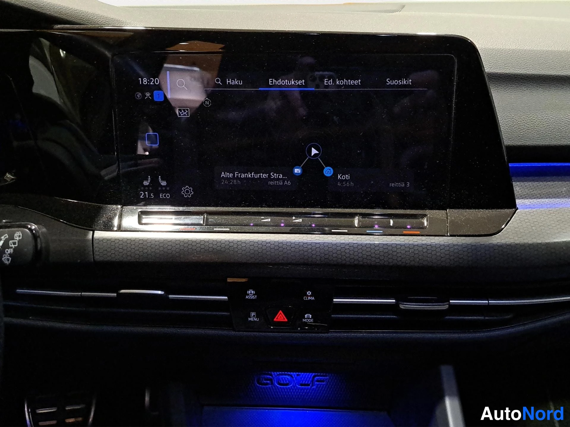 Muu: Kojelaudan infotainment-näyttö näyttää navigointireittiä kohteeseen Koti, alareunassa GOLF-teksti sinisellä valaistuksella.