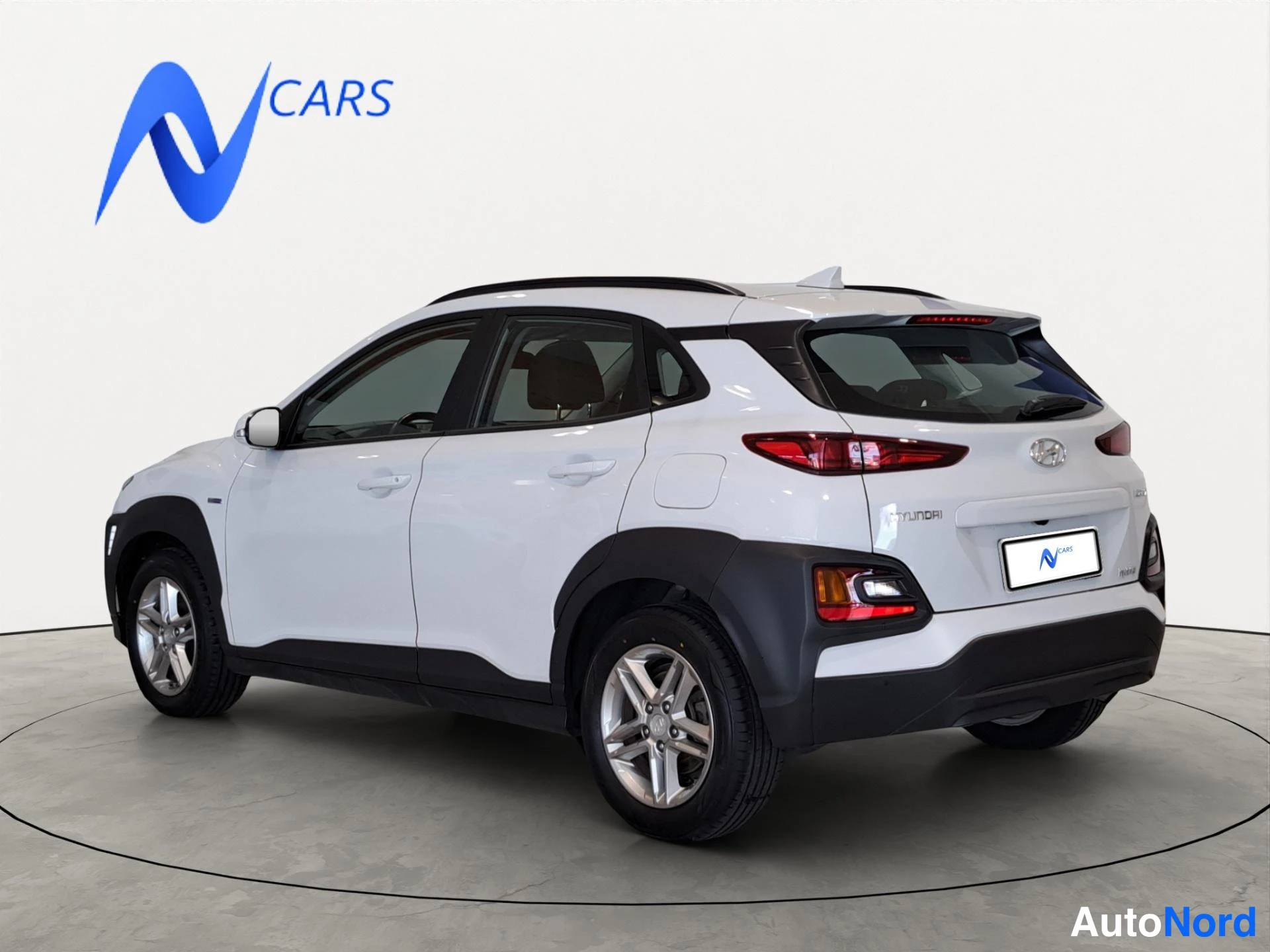 Takaviisto: Hyundai Kona -maastauton taka- ja vasen sivuprofiili valkoisena, peräosa ja takavalot näkyvät, auton fourisosainen studiossa.
