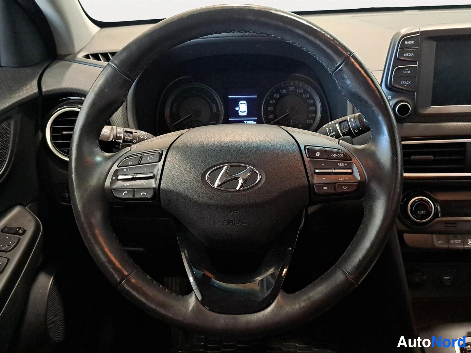 Takaa: Autoon sisäkuva Hyundai-ohjauspyörästä, kojelaudan mittaristo ja radioinfotainment-järjestelmä näkyvät, risteysruuvi RES+ ja SET- päällä.