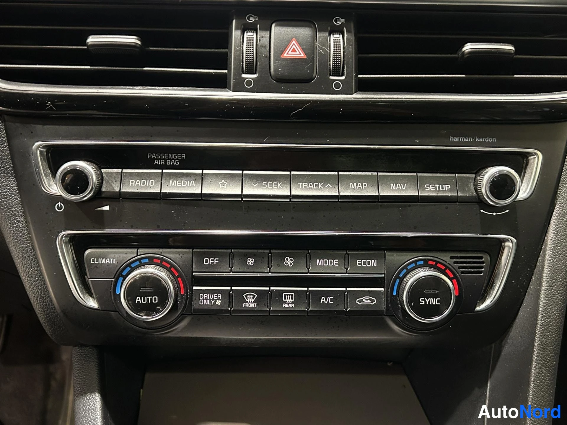 Yksityiskohta: Keskikonsolin äänentoisto- ja ilmastointipaneeli: radio/media/NAV-napit, harman/kardon -merkintä, kaksitoistinen automaattinen ilmastointi AUTO- ja SYNC-napeill