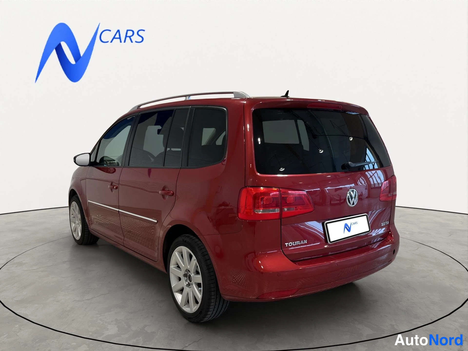 Takaviisto: Punainen Volkswagen Touran takakulmasta oikealta, perä ja sivu näkyvissä; takapaneelissa TOURAN- ja 2.0 TDI -merkinnät.