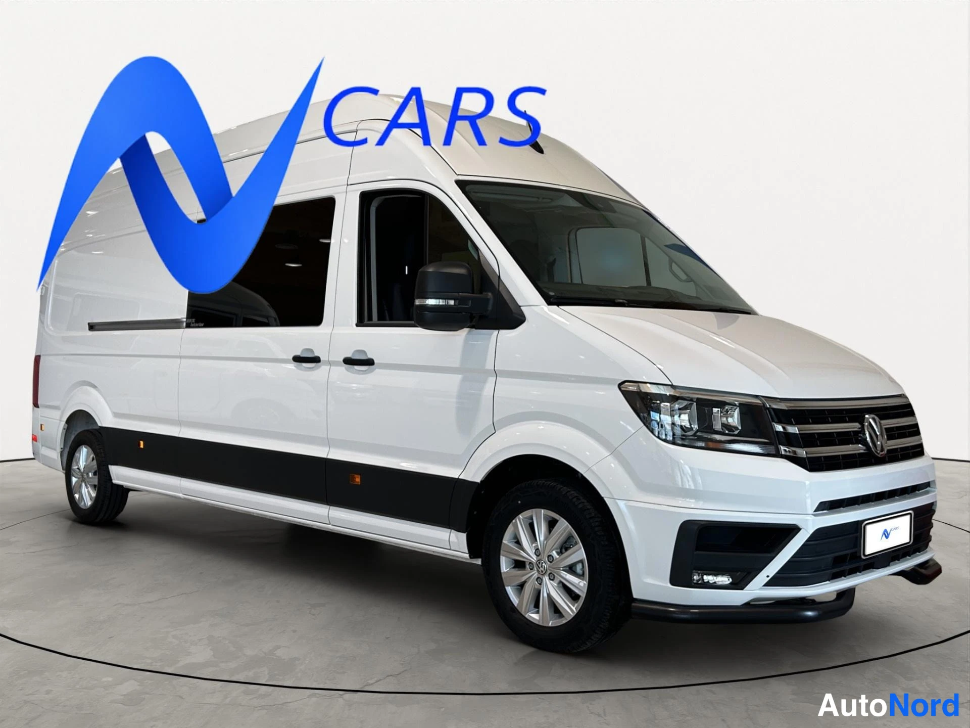 Etuviisto, nokka oikealle: Valkoinen Volkswagen Crafter -pakettiauto kuvattu kolmesta neljäsosaan edestä, keula oikealla