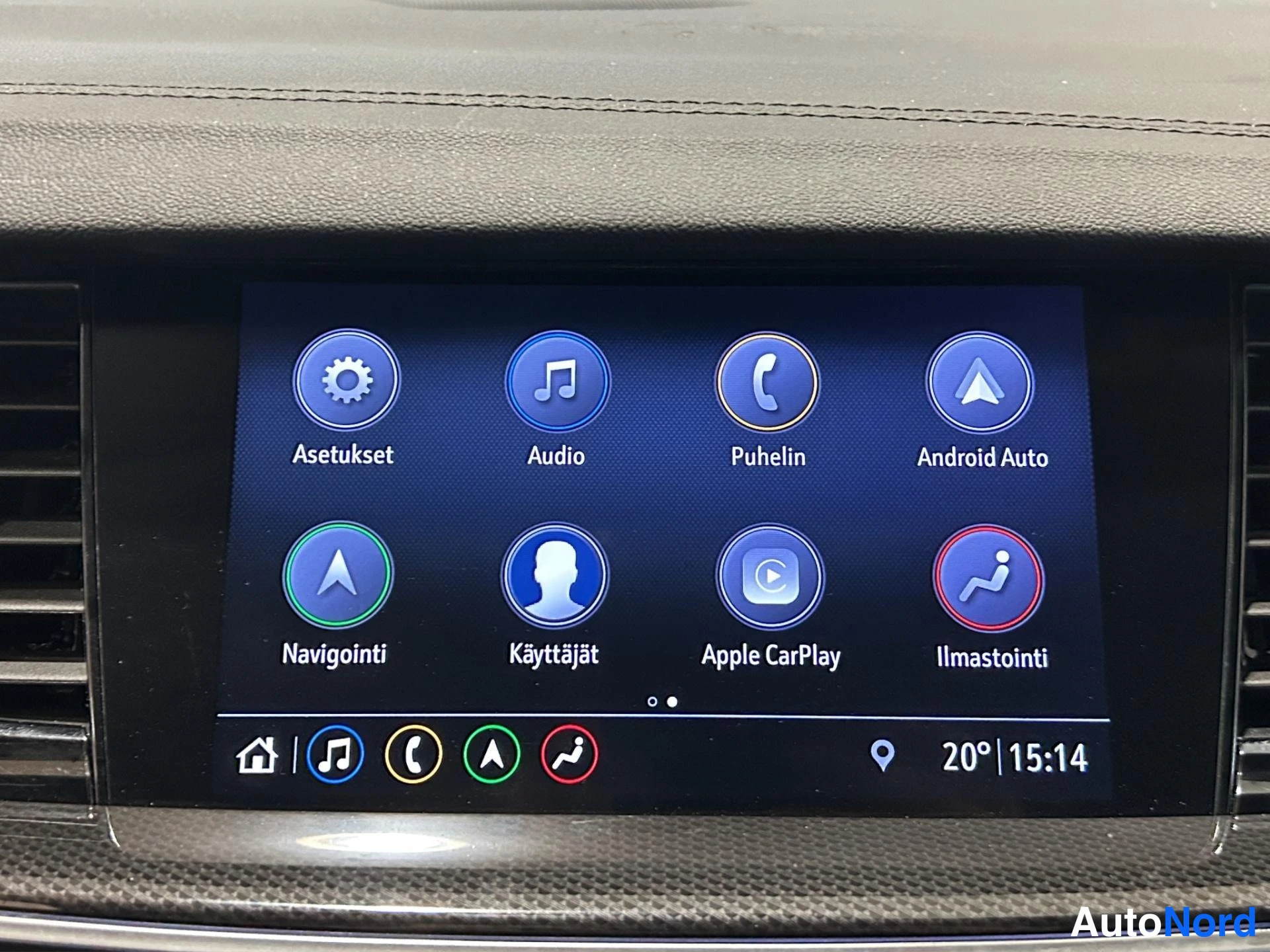 Sivulta: Kojelaudan infotainment-näyttö valikkoineen: Asetukset, Audio, Puhelin, Android Auto, Navigointi, Käyttäjät, Apple CarPlay ja Ilmastointi; kello 15:14 ja lämpöt
